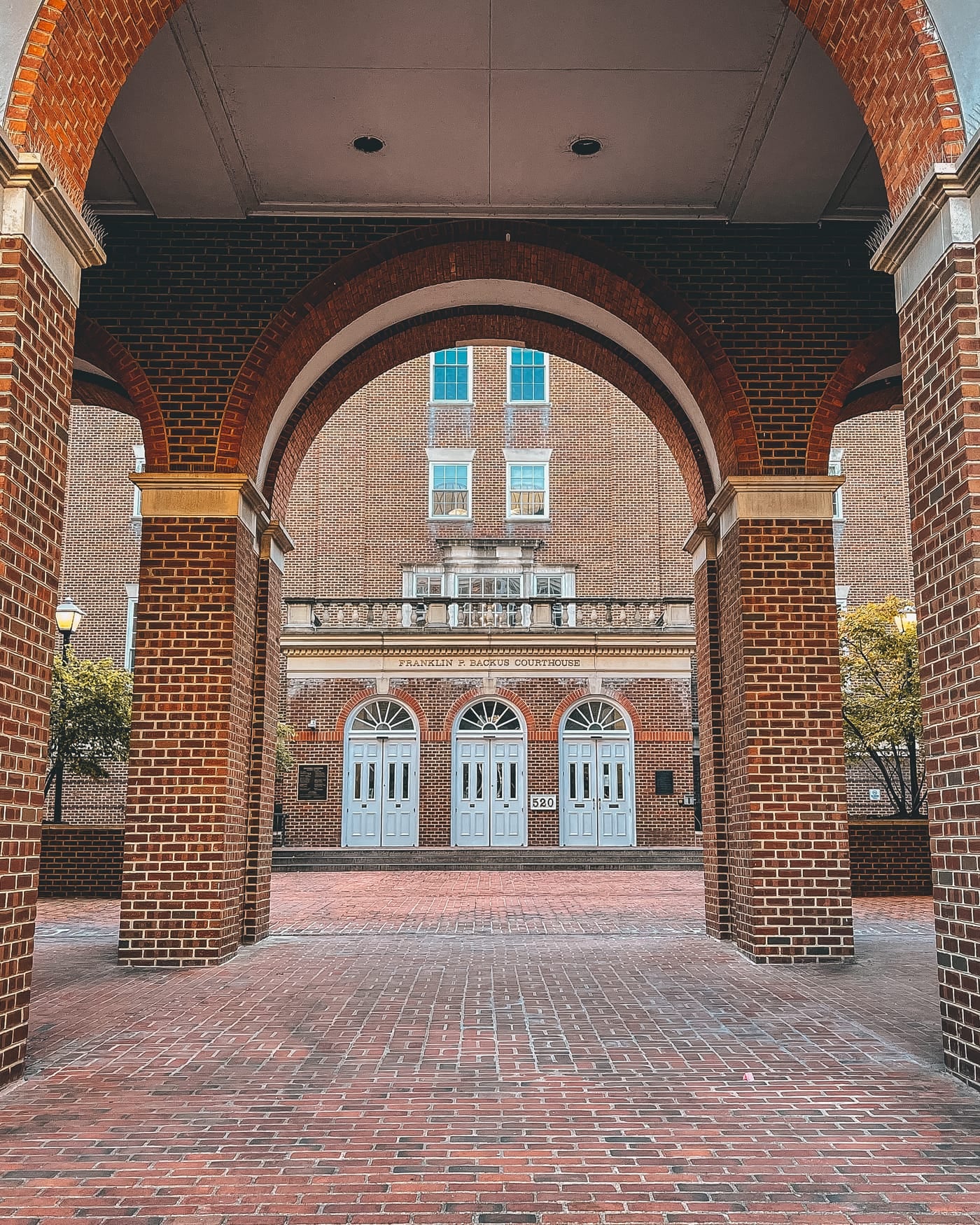 Red-brick archways framing the courtyard entrance of a courthouse