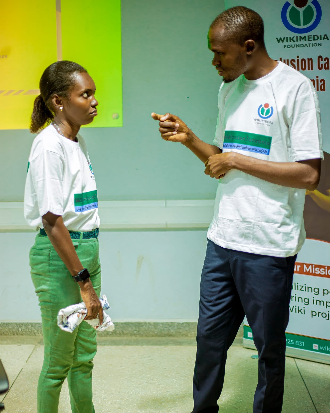 Sign language interpreter signing to a participant in a bright hallway