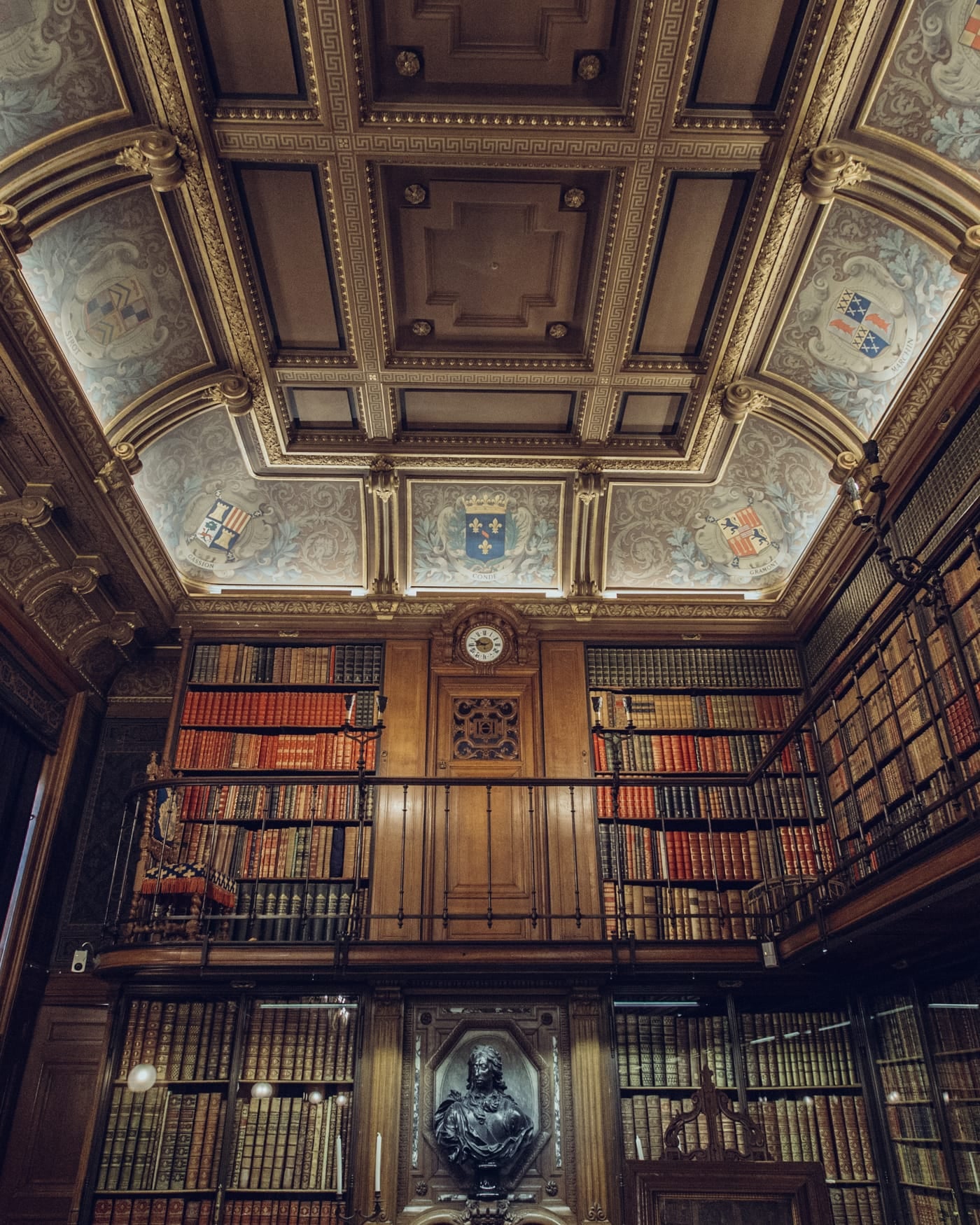 Ornate historic library hall with carved ceiling and tall bookcases