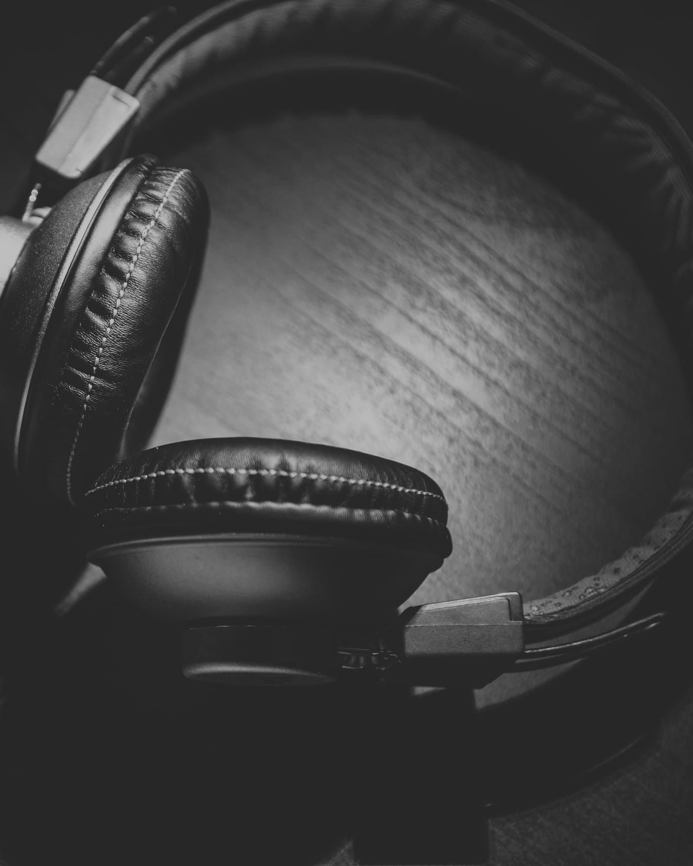 Over-ear headphones resting on a wooden surface in black and white