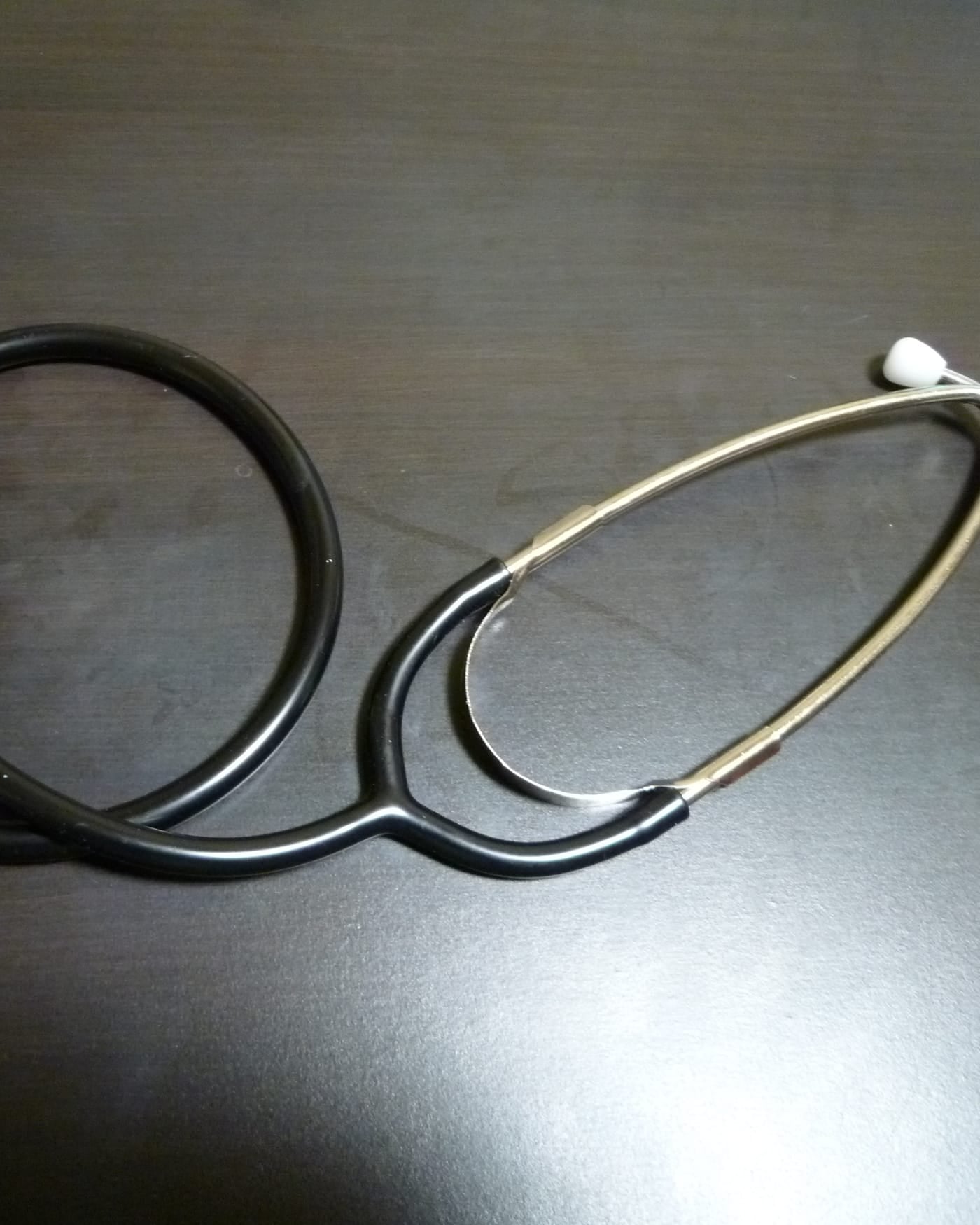 Stethoscope coiled on a dark wooden desk