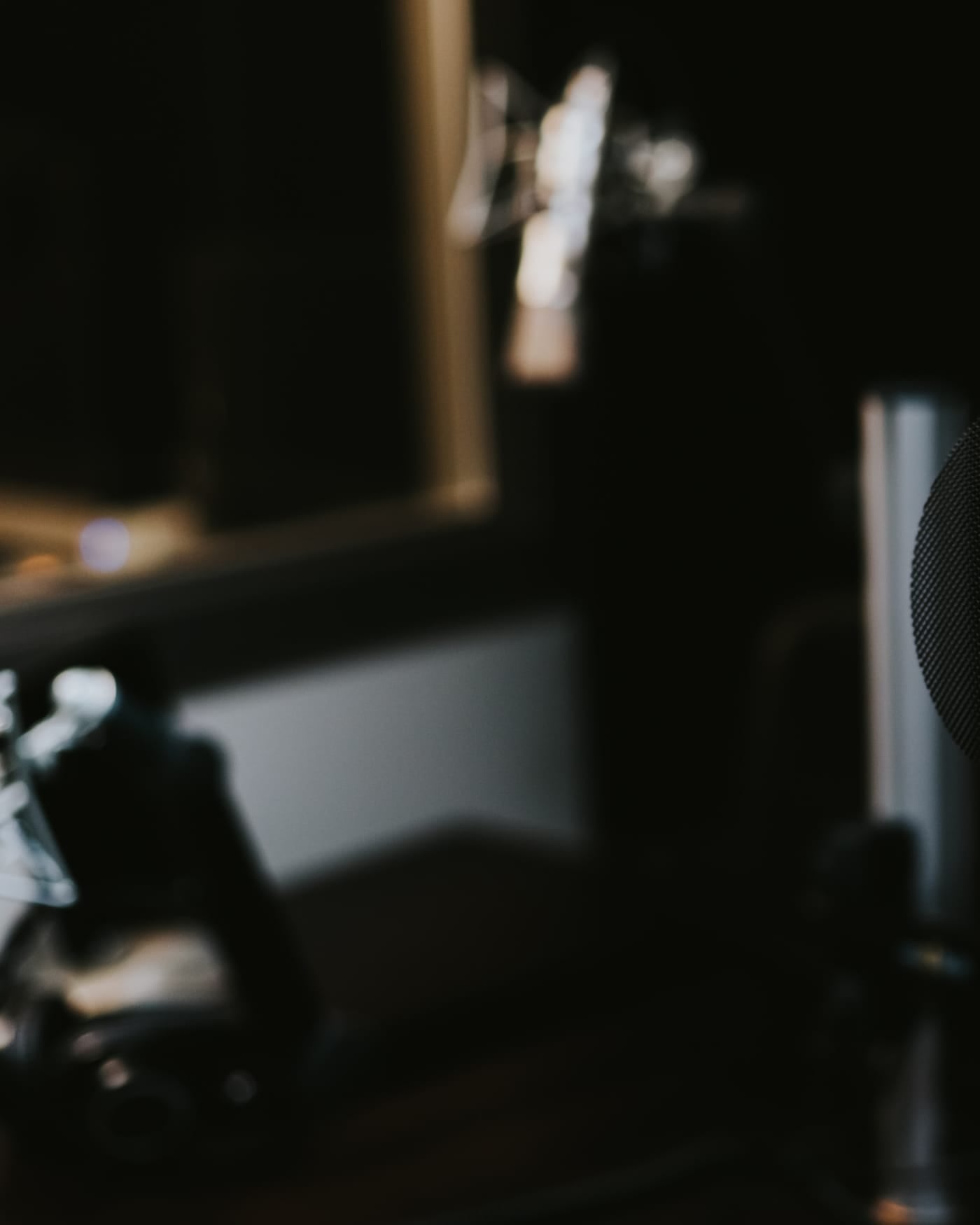 Condenser studio microphone with pop filter in a dim recording booth