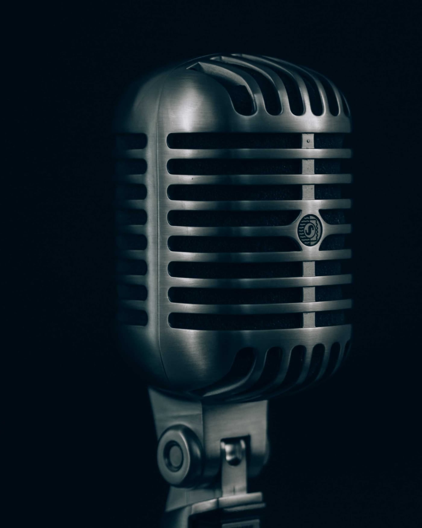 Classic steel microphone on a stand against a black background