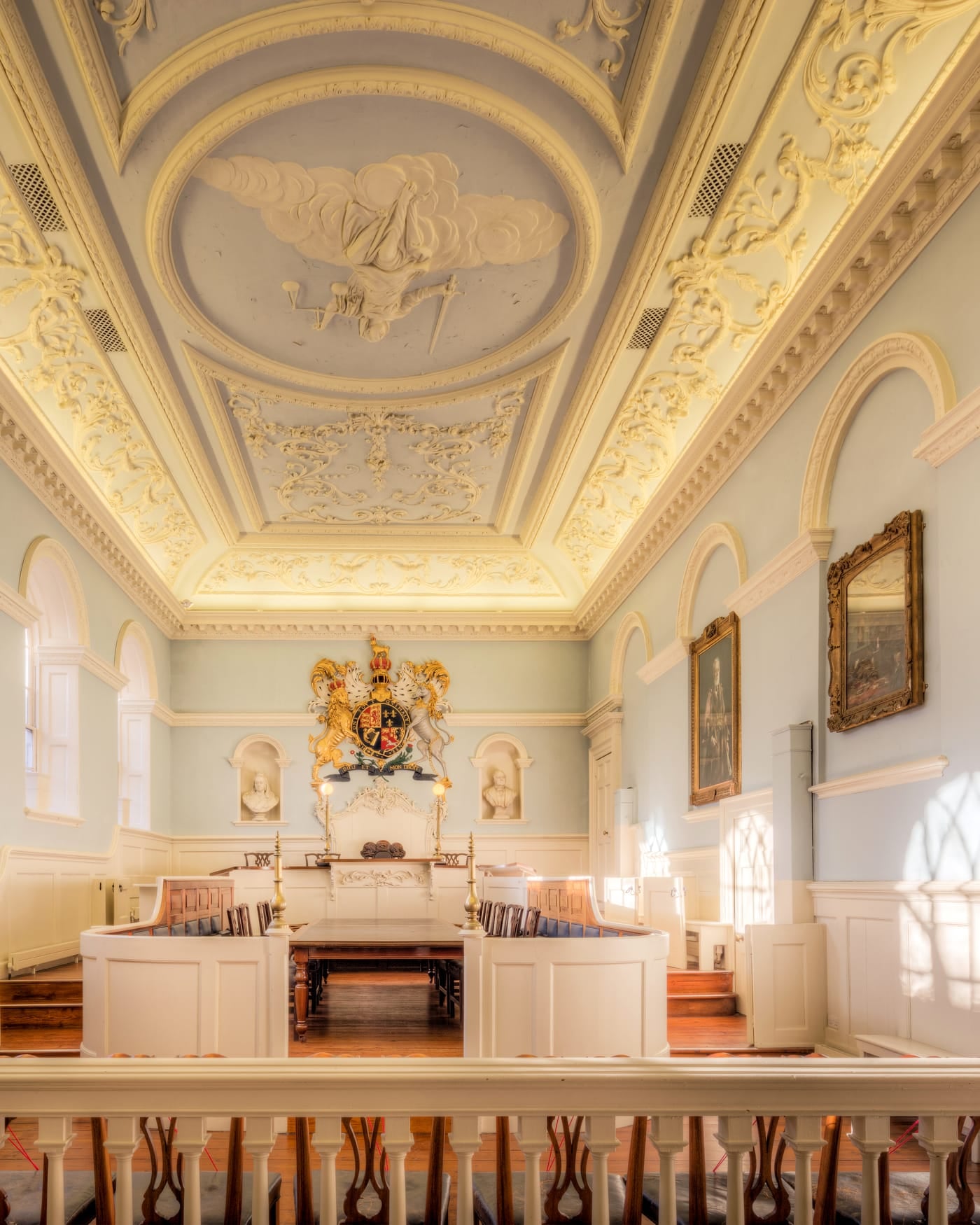 Historic courtroom with ornate plaster ceiling and wooden benches